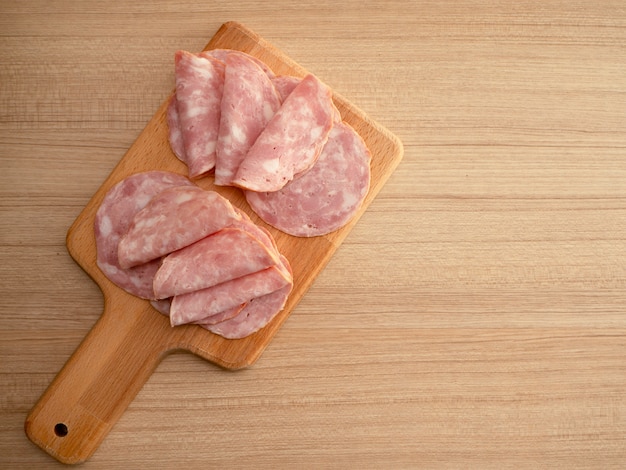 Tocino en rodajas sobre un fondo de madera