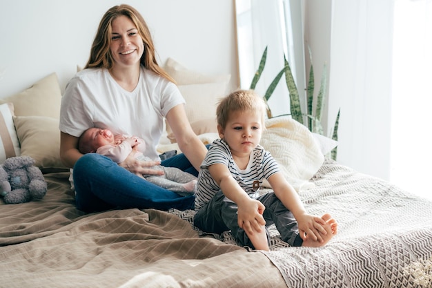 Toda la duración de una familia feliz relajándose en la cama en casa
