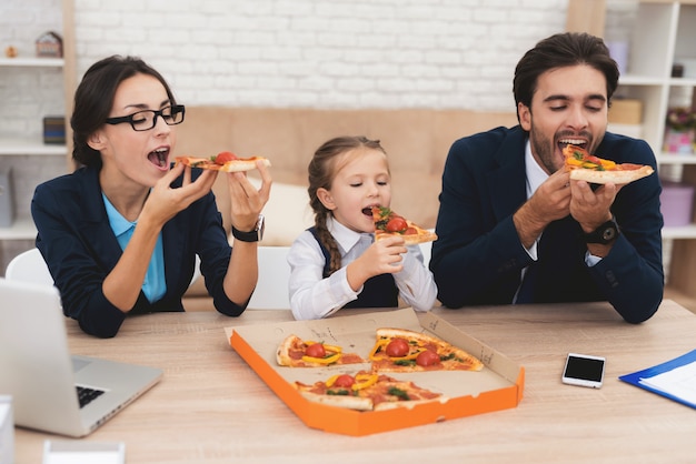 Toda la familia come pizza en casa con mucho gusto.