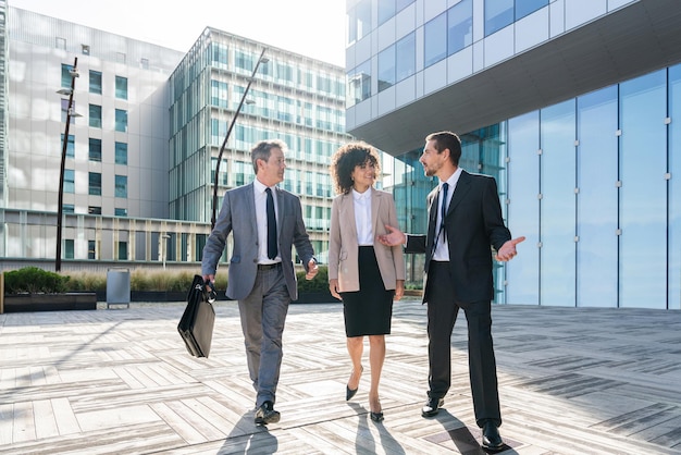 Toda la longitud de los colegas de negocios de pie en la ciudad