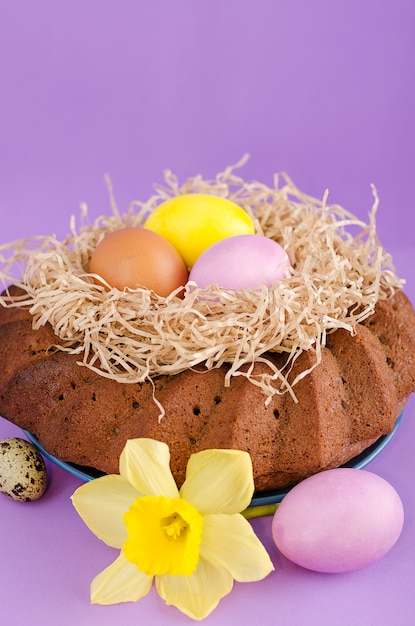 Todavía de Pascua vida, torta de Pascua, pollo y huevos de codornices, en un fondo violeta.