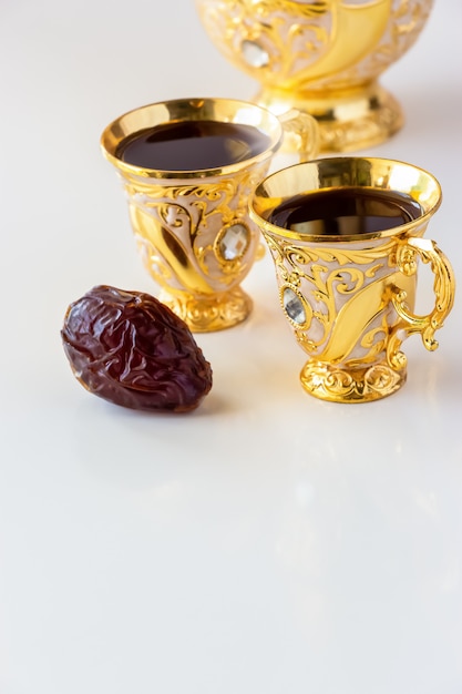 Foto todavía vida con el juego de café árabe de oro tradicional con dallah y la taza de té. el concepto de ramadán.