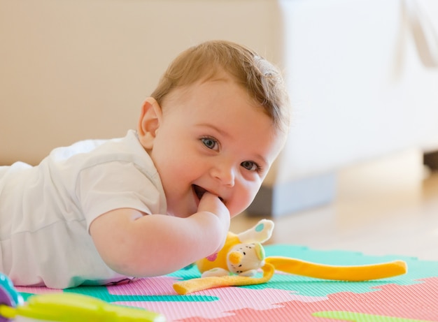 Toddler joga no chão.