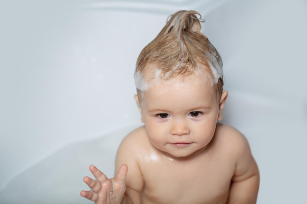 Todler en la ducha niño en la bañera con pompas de jabón mullidas bebé feliz tomando un baño jugando con espuma b