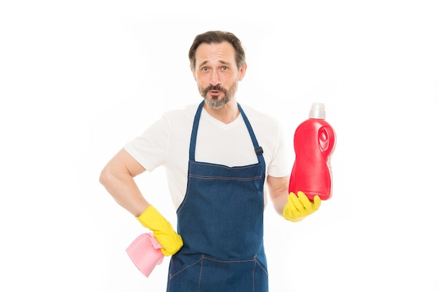 Todo debería estar perfecto. Servicio de limpieza y deberes domésticos. El hombre con guantes de goma sostiene una botella de jabón líquido con agente de limpieza químico. Chico barbudo limpiando la casa. Concepto de limpieza en casa. Frote para brillar.