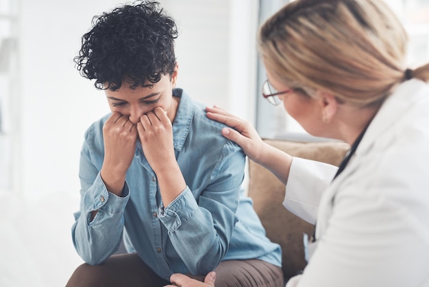 Foto todo estará bien si sigue su tratamiento captura recortada de una joven doctora compasiva que consuela a una paciente en su consultorio