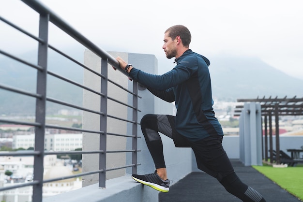 Todo el progreso tiene lugar fuera de la zona de confort Foto de un joven deportista que se estira mientras hace ejercicio al aire libre