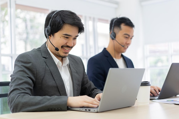 todos los agentes del centro usan auriculares y sonríen trabajando en la sala de operaciones