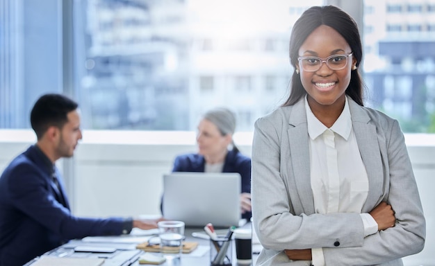 Todos foram dedicados a fazer um trabalho incrível Retrato de uma jovem empresária confiante em um escritório com seus colegas ao fundo