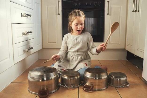 Esta va para todos mis fans Foto de una niña pequeña tocando la batería en un juego de ollas en la cocina