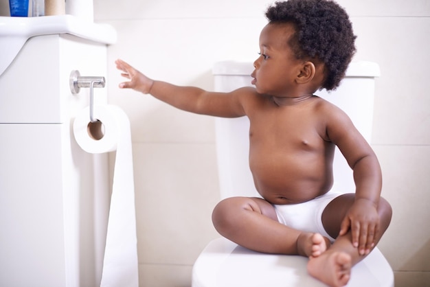 Töpfchentraining 101 Achte immer darauf, dass du genug Toilettenpapier hast Aufnahme eines kleinen Jungen, der auf der Toilette sitzt und nach dem Toilettenpapier greift