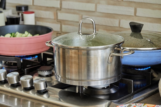 Töpfe mit kochendem Essen in der Küche auf Gasherd