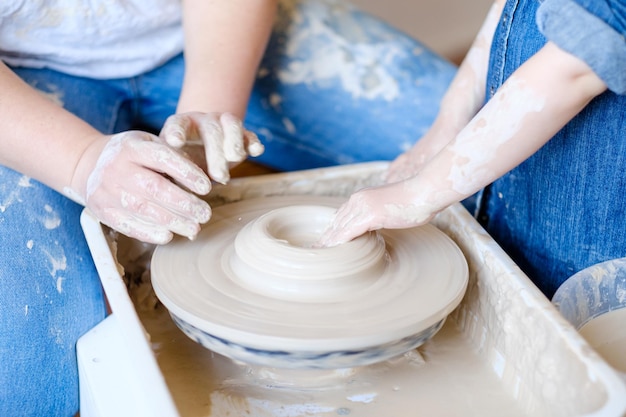 Töpferhandwerk traditionelle Kunst der Herstellung von Keramiktöpfer und ein kleiner Student, der Ton auf dem Drehrad modelliert