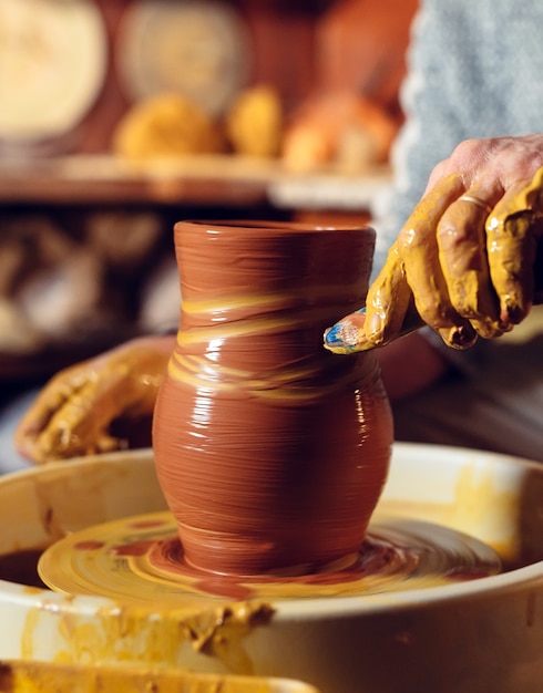 Töpferwerkstatt. Ein älterer Mann stellt eine Vase aus Ton her. Tonmodellierung