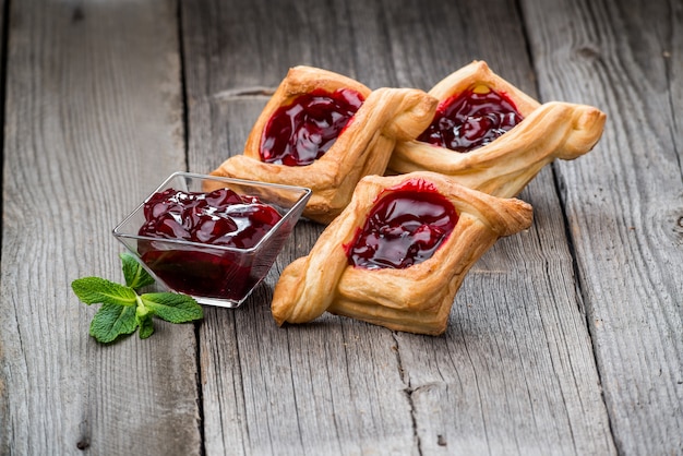 Törtchen der frischen Frucht mit Beerenmarmelade, Minze auf Holztisch. Wüste.