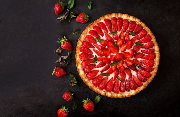 Törtchen mit Erdbeeren und Schlagsahne mit Minzblättern verziert.