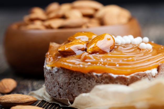 Törtchen mit Milchkäsefüllung und viel Salzkaramell mit Nüssen, Mandeln auf Törtchen mit Hüttenkäse oder Buttercreme und Karamell, leckere Desserts