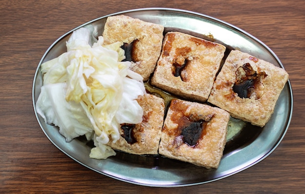 Tofu apestoso frito, tofu fermentado con vegetales de repollo en escabeche, comida callejera famosa y deliciosa en Taiwán, estilo de vida.