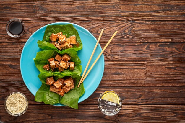 Tofu frito com molho de soja e gergelim em folhas verdes de espinafre