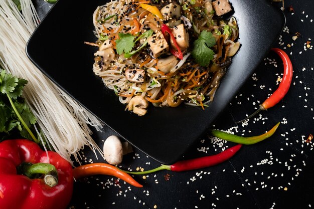 Tofu frito con fideos y verduras en un plato. cocina tradicional japonesa preparando comida artesanal