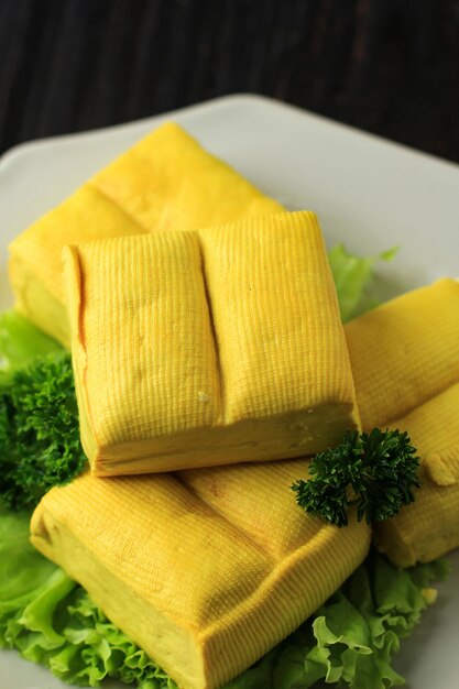 Tofu suave amarillo y fondo de mesa de madera Comida asiática