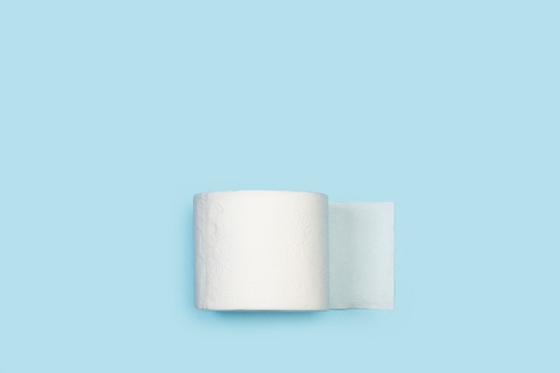 Toilettenpapierrolle auf einem hellblauen Hintergrund in einer Draufsicht