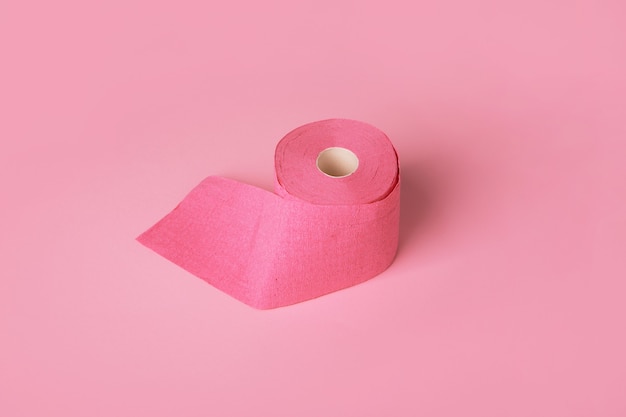 Toilettenpapierrolle über rosa Hintergrund, Körperpflegeartikel