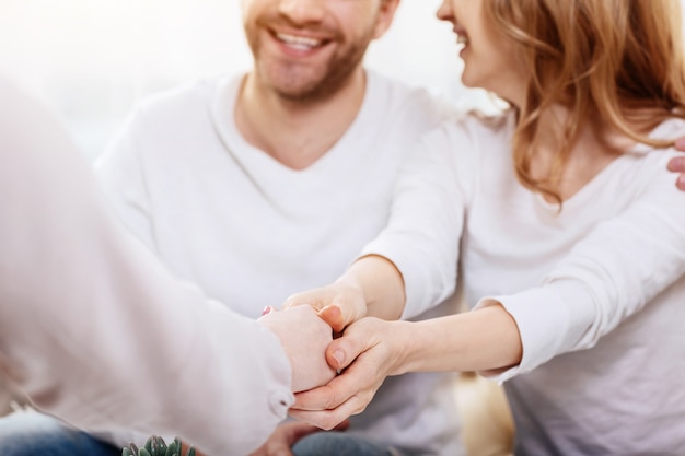 Tolle Beziehungen. Nahaufnahme eines Händedrucks eines Psychologen und einer netten fröhlichen attraktiven Frau beim Beenden einer psychologischen Sitzung