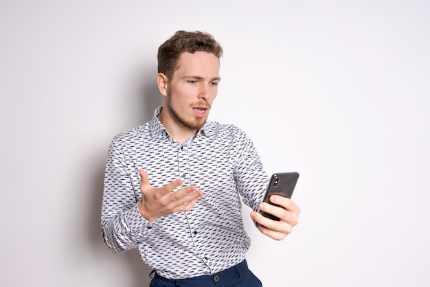 Tolle Neuigkeiten von einem Freund Schöner junger kaukasischer Mann mit Smartphone