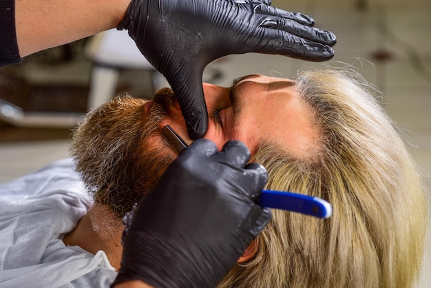 Tolle Zeit beim Friseur. bärtiger mann beim friseur. professioneller friseur mit männlichem kunden. Hipster mit Bart und Schnurrbart. Mann will neue Frisur. Schönheit und Mode. reifer Mann im Friseursalon.