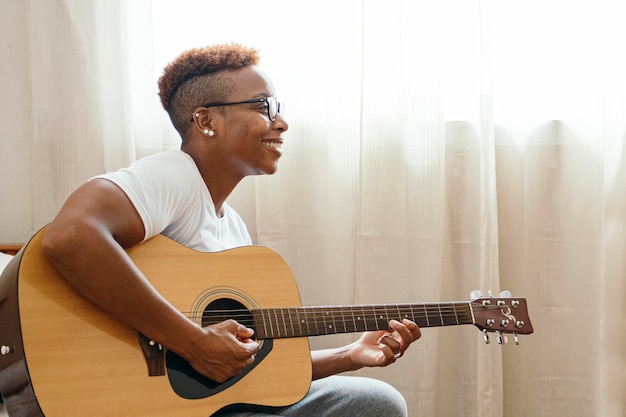 Tom boy feliz tocando la guitarra