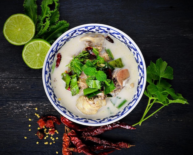 Tom Kha Kai sobre fondo de mesa de madera negra con concepto de comida tailandesa