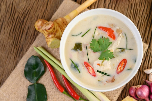 Tom Kha Kai en un tazón con hojas de lima kaffir hierba de limón cebolla roja galangal y chile