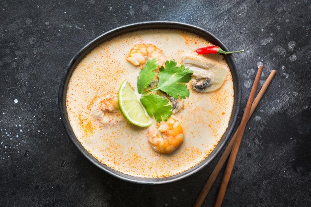 Tom Yam Kung würzige Thai-Suppe mit Garnelen, Meeresfrüchten, Kokosmilch, Chilischote und Reis Ansicht von oben