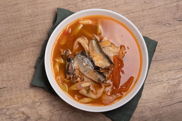 Foto tom yum pescado enlatado en una taza sopa picante