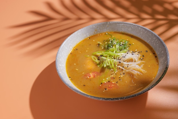 Tom Yum-Suppe auf orangefarbenem Hintergrund mit Platz für Text oben