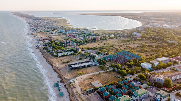 Toma aérea de drones de la ciudad costera con hermosa playa y océano