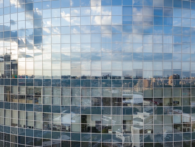 Toma aérea de las ventanas del edificio de oficinas moderno, reflejo del paisaje urbano en un día soleado en Kiev, Ucrania.