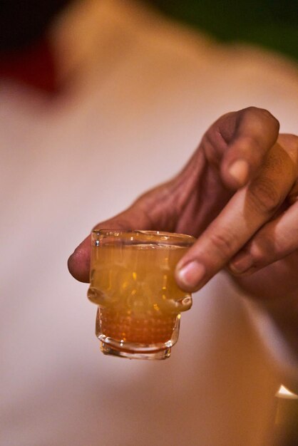 Toma de bebida alcohólica en un concepto de mixología de vidrio en forma de calavera