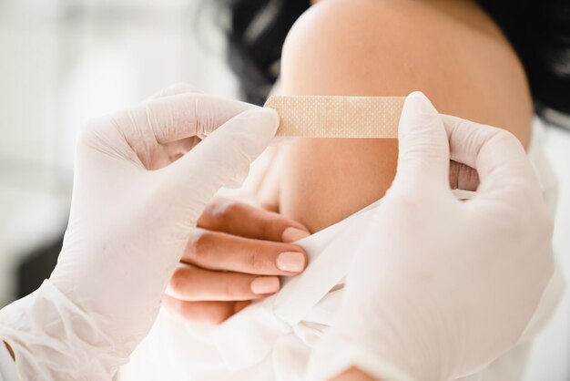 Una toma de cerca del concepto de vacunación Un médico hace una inyección contra el coronavirus Covid-19 a una paciente femenina en el hospital para detener la pandemia