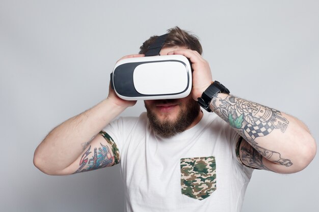 Toma en color de un joven mirando a través de una realidad virtual, un dispositivo con el que se puede experimentar la realidad virtual en un teléfono móvil. el hombre toca la mano. fotos borrosas