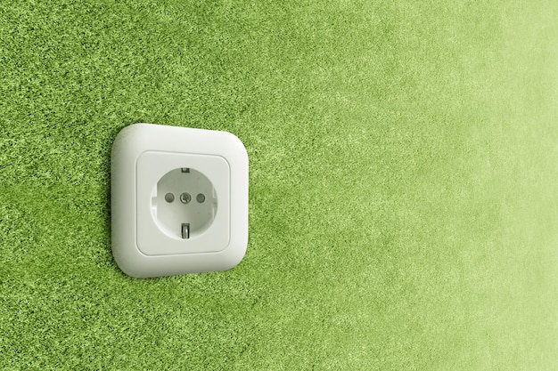 Toma de corriente de pared verde. Concepto de energía verde