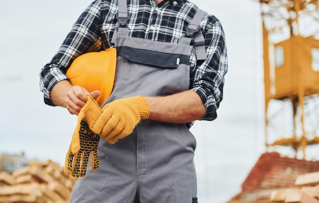 Toma un descanso Trabajador de la construcción en uniforme y equipo de seguridad tiene trabajo en la construcción