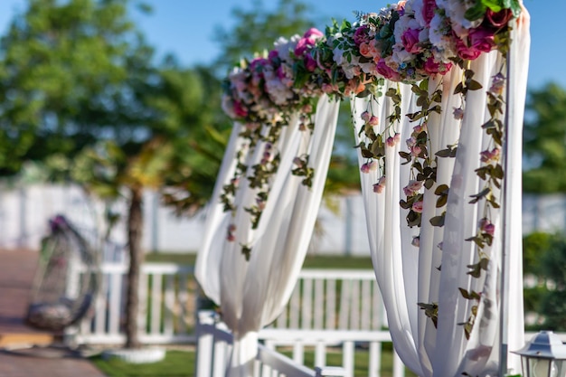 Toma de enfoque selectiva de un arco de flores con cortinas para una fiesta al aire libre