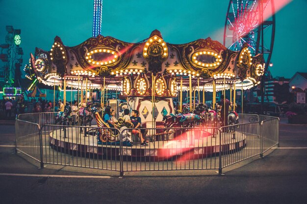 Una toma de enfoque superficial de un carrusel brillante en un parque de atracciones por la noche