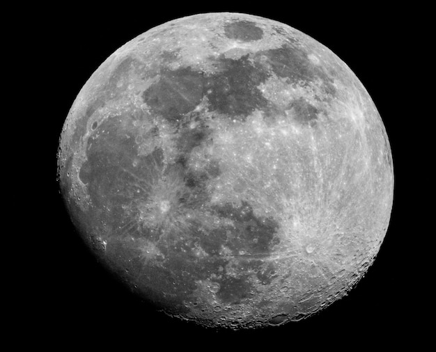 Una toma en escala de grises de una luna llena sobre un fondo negro