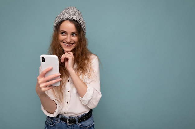 Toma de la foto de atractiva mujer joven de buen aspecto positivo vistiendo casual elegante atuendo aplomo