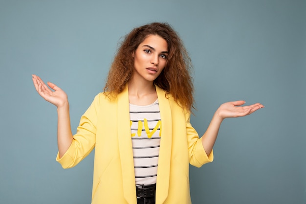 Toma de foto de joven preguntando pensando bonita linda mujer rizada morena con sinceras emociones vistiendo