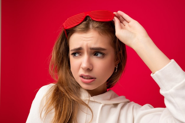 Toma de foto en primer plano de hermosa mujer rubia joven triste con ropa casual y elegante óptica