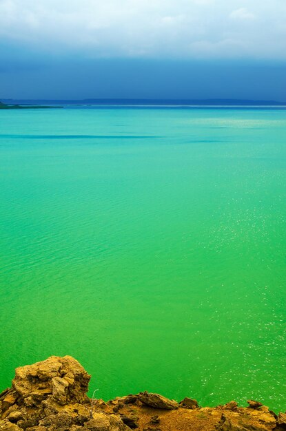 Foto una toma idílica del mar verde contra el cielo nublado